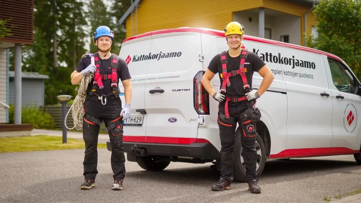 Kaksi Kattokorjaamon asentajaa huoltoauton edessä